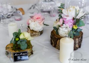 Des fleurs et des rondins de bois pour décorer les tables de réception du mariage